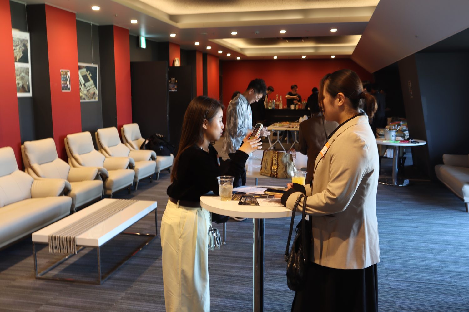 VIPルームのソファ席で話し込む参加者